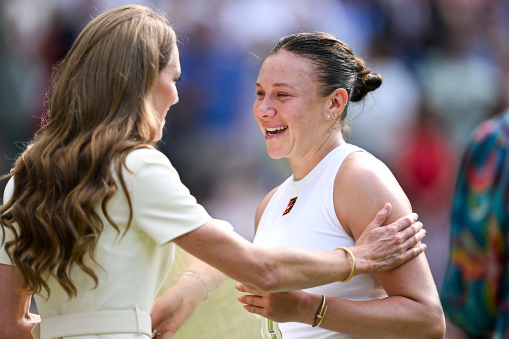 Britain's Catherine, Princess of Wales (L) comforts as she gives the runner up trophy, to US player Amanda Anisimova after her defeat against Poland's Iga Swiatek at the end of their women's singles final tennis match on the thirteenth day of the 2025 Wimbledon Championships 